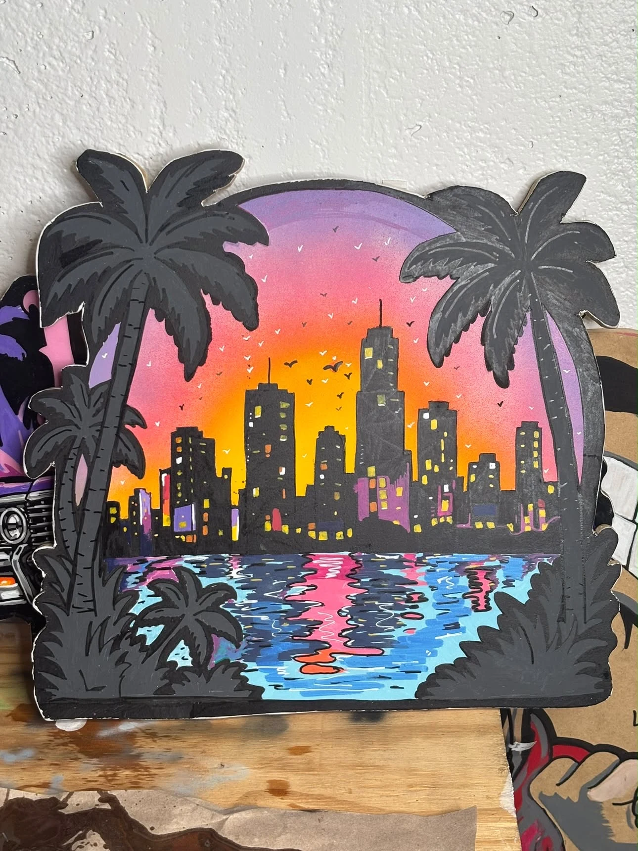 Miami Afterglow: hand-painted palm trees, city skyline and water reflections on wood, photographed on the artist’s work surface